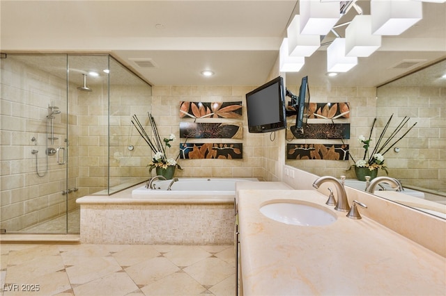 bathroom featuring visible vents, a shower stall, vanity, a garden tub, and tile walls