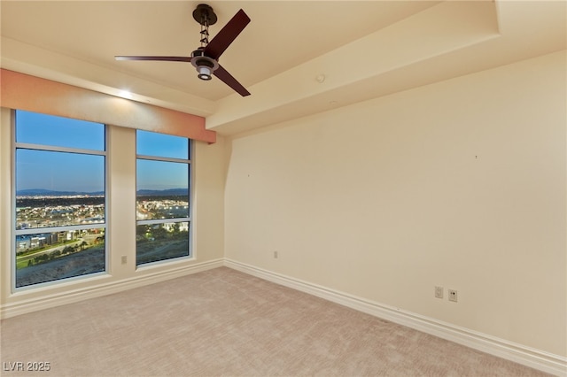 carpeted empty room with baseboards and ceiling fan