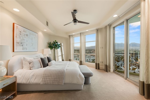 carpeted bedroom with access to exterior, multiple windows, recessed lighting, and a mountain view