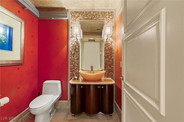 bathroom featuring vanity, toilet, and baseboards