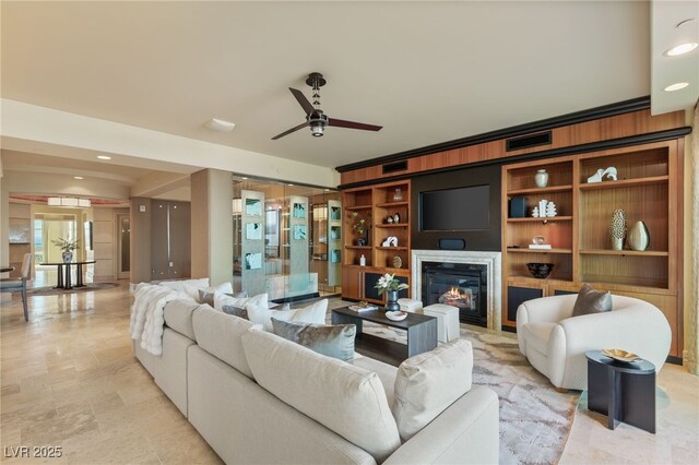 living room with a glass covered fireplace, recessed lighting, a ceiling fan, and visible vents