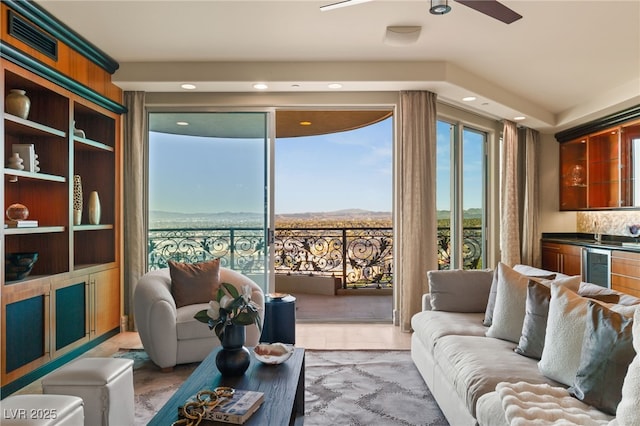 living room featuring wine cooler, wet bar, and ceiling fan