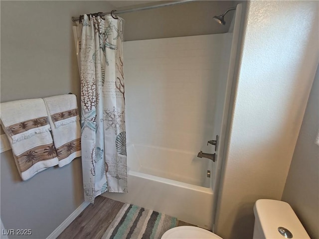 bathroom with toilet, wood finished floors, and shower / tub combo with curtain