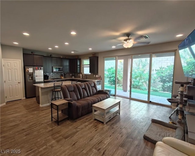 living area with recessed lighting, visible vents, dark wood-type flooring, and a ceiling fan