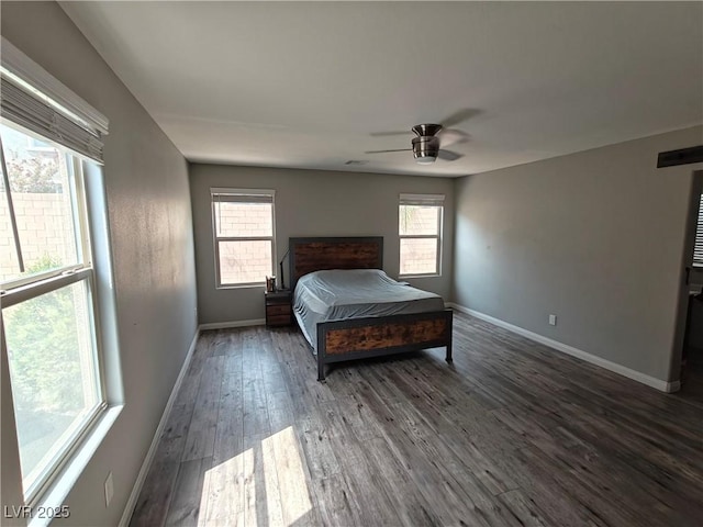 bedroom featuring ceiling fan, baseboards, multiple windows, and dark wood-style floors