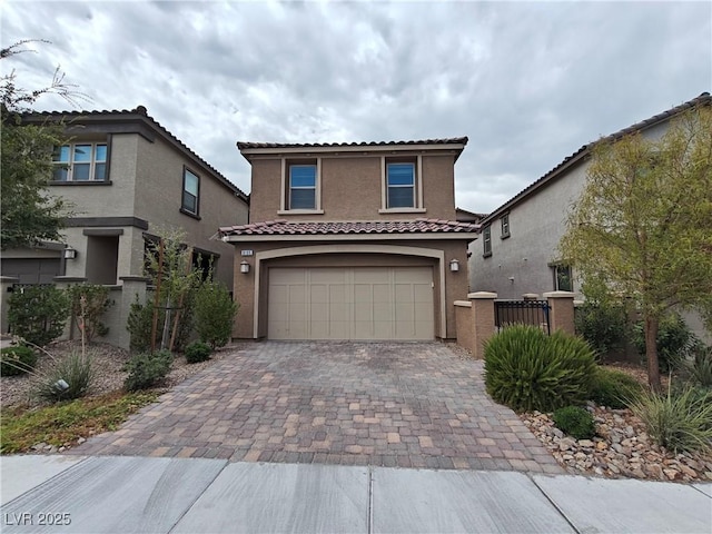 mediterranean / spanish-style house with stucco siding, decorative driveway, fence, an attached garage, and a tiled roof