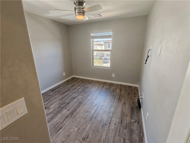 unfurnished room featuring a ceiling fan, wood finished floors, visible vents, and baseboards