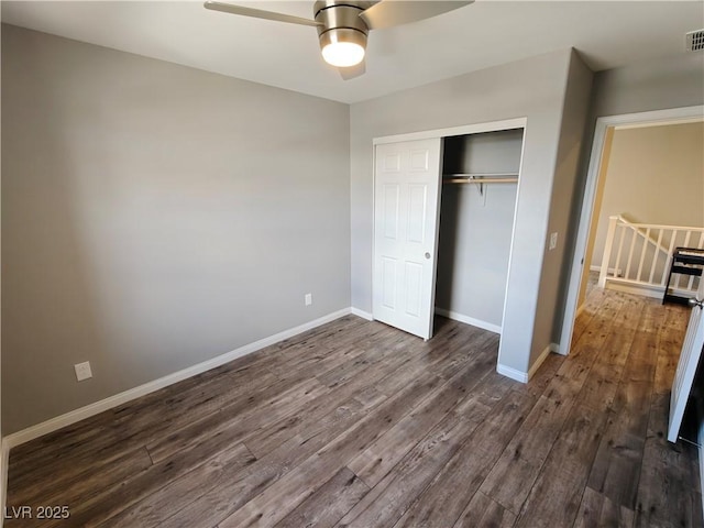 unfurnished bedroom with visible vents, dark wood-style floors, baseboards, and a closet