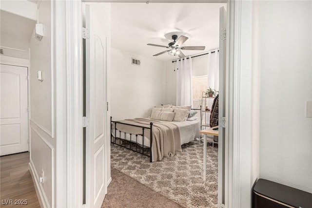 bedroom featuring visible vents, ceiling fan, and wood finished floors