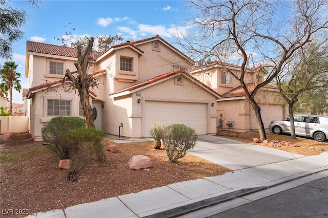 mediterranean / spanish-style home with fence, driveway, stucco siding, a garage, and a tiled roof