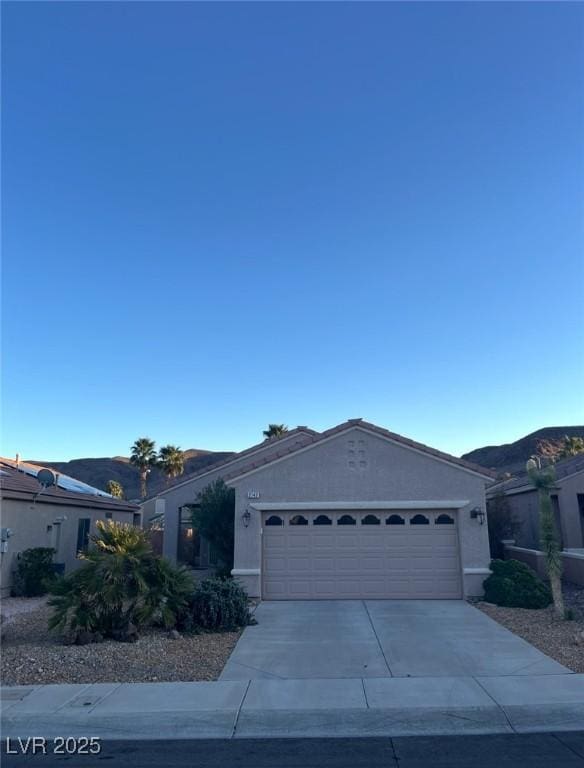 ranch-style home with stucco siding, an attached garage, and concrete driveway