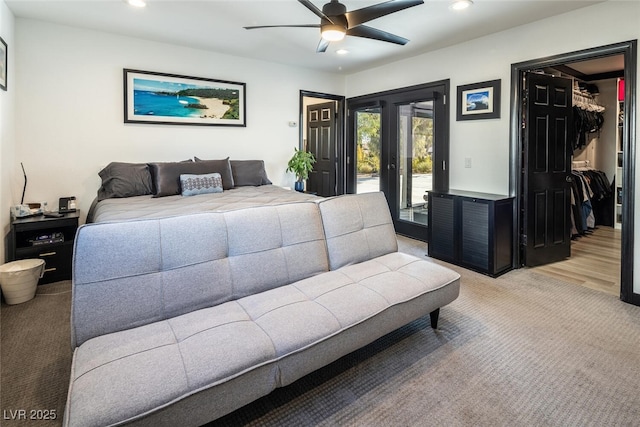 bedroom with recessed lighting, ceiling fan, light carpet, a walk in closet, and access to outside