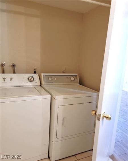 washroom featuring light tile patterned flooring, laundry area, and washer and clothes dryer