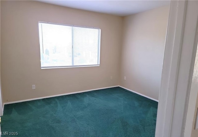 spare room with dark carpet and baseboards