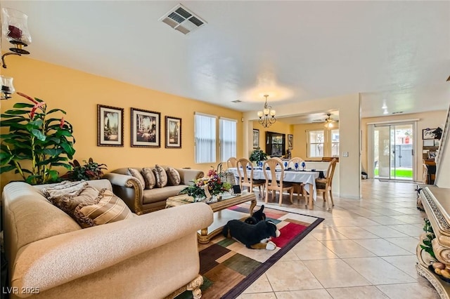 living area with a notable chandelier, visible vents, and light tile patterned flooring