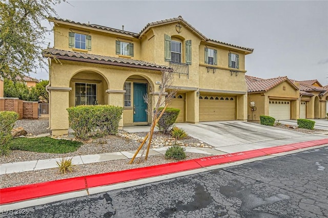 mediterranean / spanish-style house with fence, an attached garage, stucco siding, concrete driveway, and a tiled roof