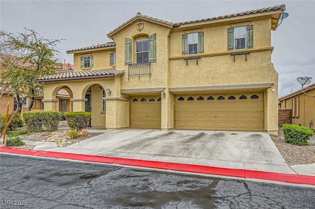 mediterranean / spanish-style home featuring a tile roof, stucco siding, concrete driveway, and a garage