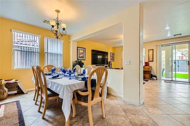 dining space featuring light tile patterned floors, visible vents, baseboards, and a notable chandelier