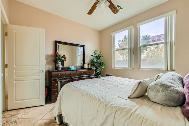 bedroom with light tile patterned floors, a ceiling fan, and visible vents