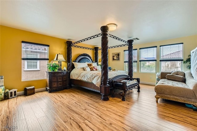 bedroom featuring visible vents, baseboards, and light wood-style floors