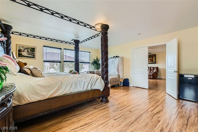 bedroom featuring fridge and light wood-style flooring