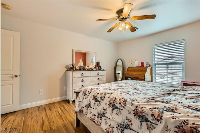 bedroom with ceiling fan, baseboards, and light wood-style flooring