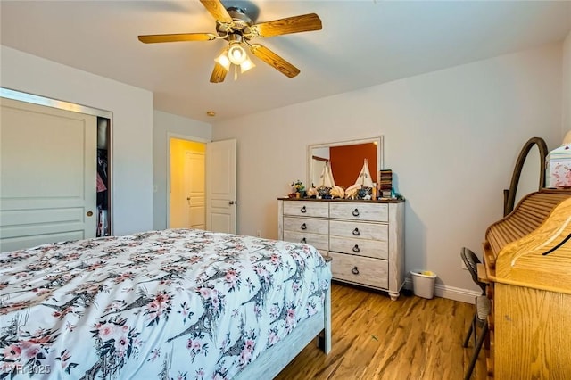 bedroom featuring a ceiling fan, wood finished floors, baseboards, and a closet