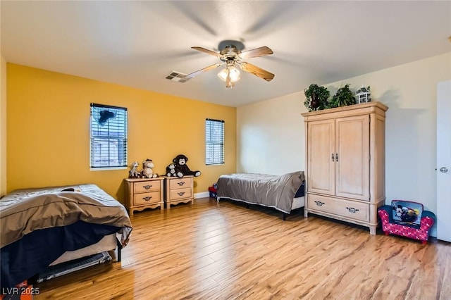 bedroom with visible vents, light wood-type flooring, and a ceiling fan