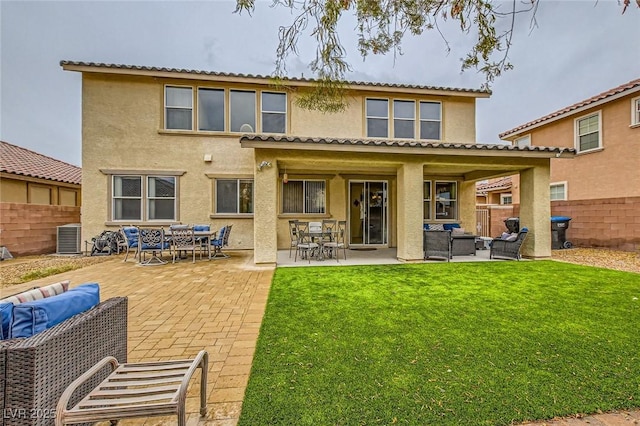 back of property with stucco siding, an outdoor living space, fence, a yard, and a patio area