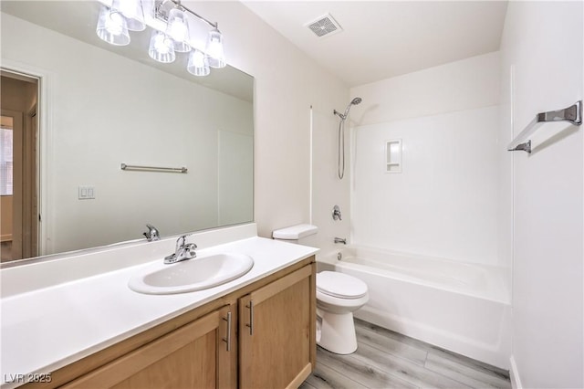 full bath featuring visible vents, tub / shower combination, toilet, wood finished floors, and vanity