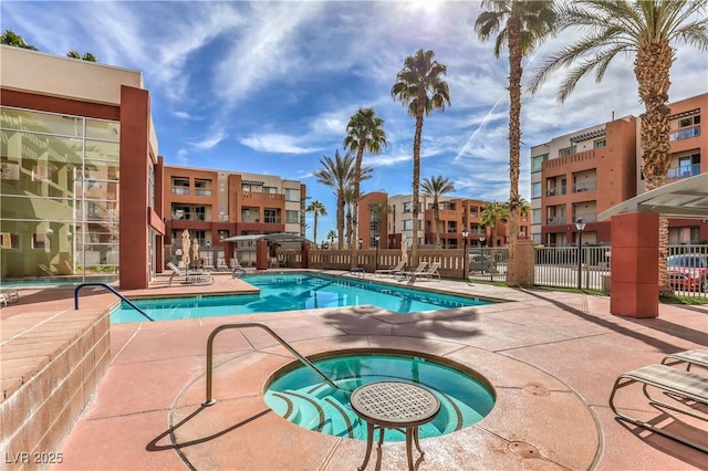 pool featuring a patio area, a community hot tub, and fence