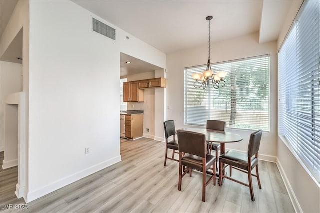 dining space featuring visible vents, baseboards, an inviting chandelier, and light wood finished floors