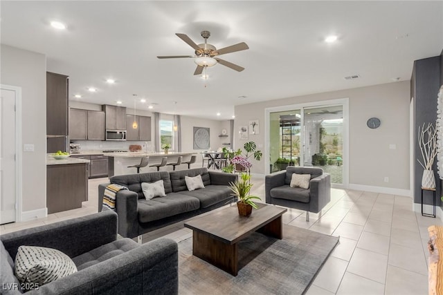 living area featuring light tile patterned floors, recessed lighting, a wealth of natural light, and ceiling fan