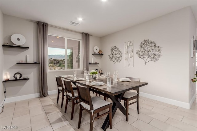 dining space with light tile patterned floors, visible vents, and baseboards