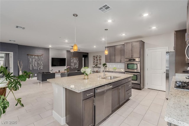 kitchen featuring backsplash, visible vents, appliances with stainless steel finishes, and a sink