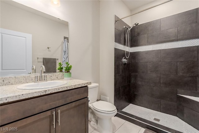 full bath with tile patterned floors, tiled shower, toilet, and vanity