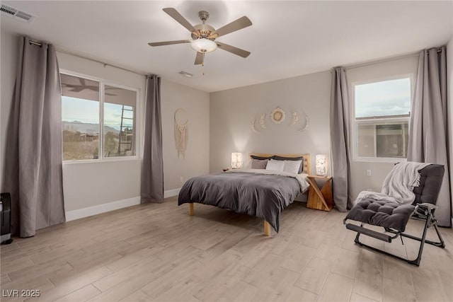 bedroom featuring ceiling fan, baseboards, visible vents, and light wood-type flooring