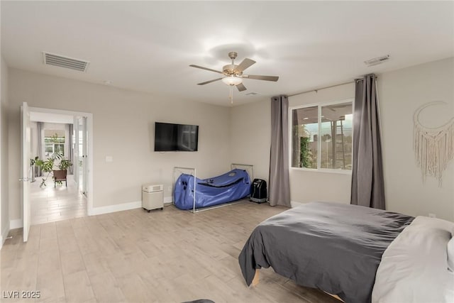 bedroom with visible vents, multiple windows, and wood finished floors