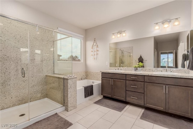 bathroom with double vanity, a sink, tile patterned flooring, a shower stall, and a garden tub