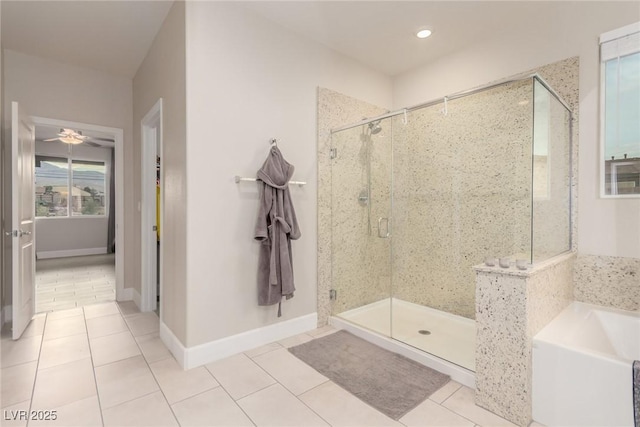 full bathroom featuring tile patterned flooring, a bath, baseboards, and a stall shower