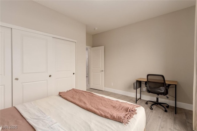 bedroom with a closet, baseboards, and wood finished floors