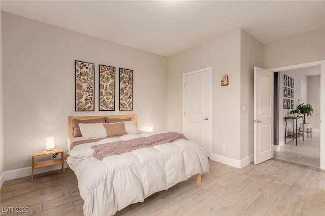 bedroom featuring baseboards and light wood-style flooring