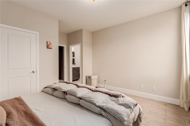 bedroom with baseboards and light wood finished floors