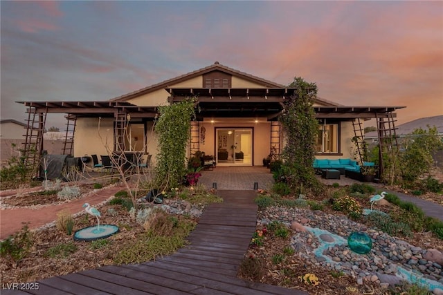 back of house with stucco siding, an outdoor hangout area, and a deck