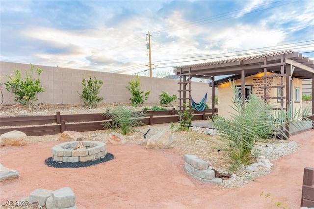 view of yard with a garden, a fire pit, a fenced backyard, and a pergola