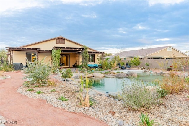 view of front facade featuring stucco siding and fence