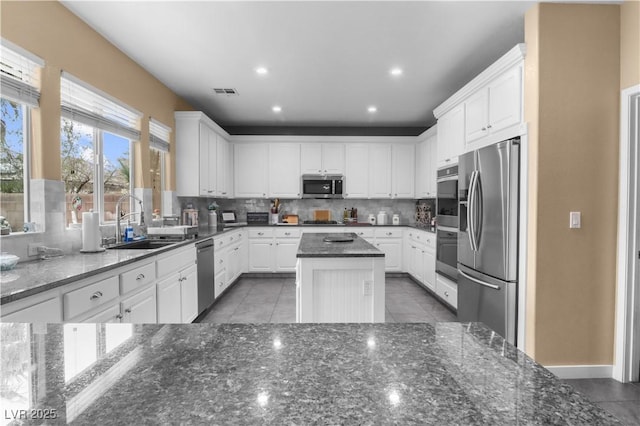 kitchen featuring a sink, white cabinets, visible vents, and stainless steel appliances