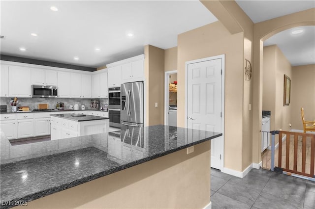 kitchen with white cabinetry, a center island, tasteful backsplash, and stainless steel appliances