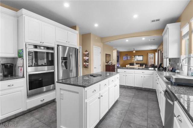 kitchen featuring a sink, stainless steel appliances, visible vents, and white cabinets