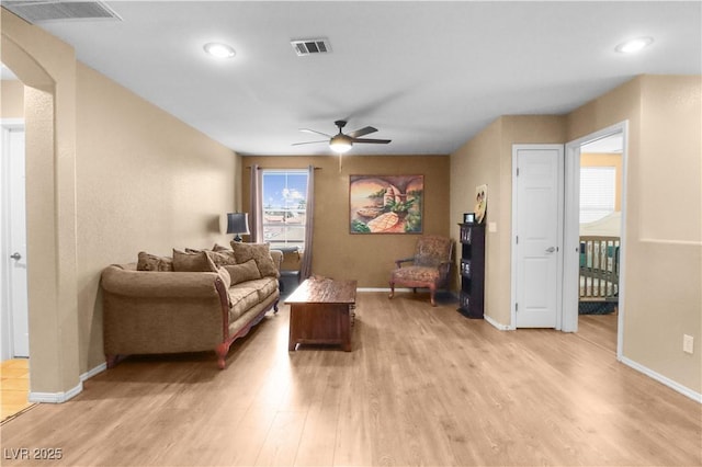 living area featuring baseboards, visible vents, and light wood-type flooring